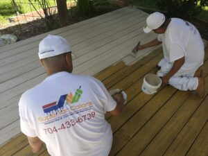 superior colors painters applying white paint to a deck